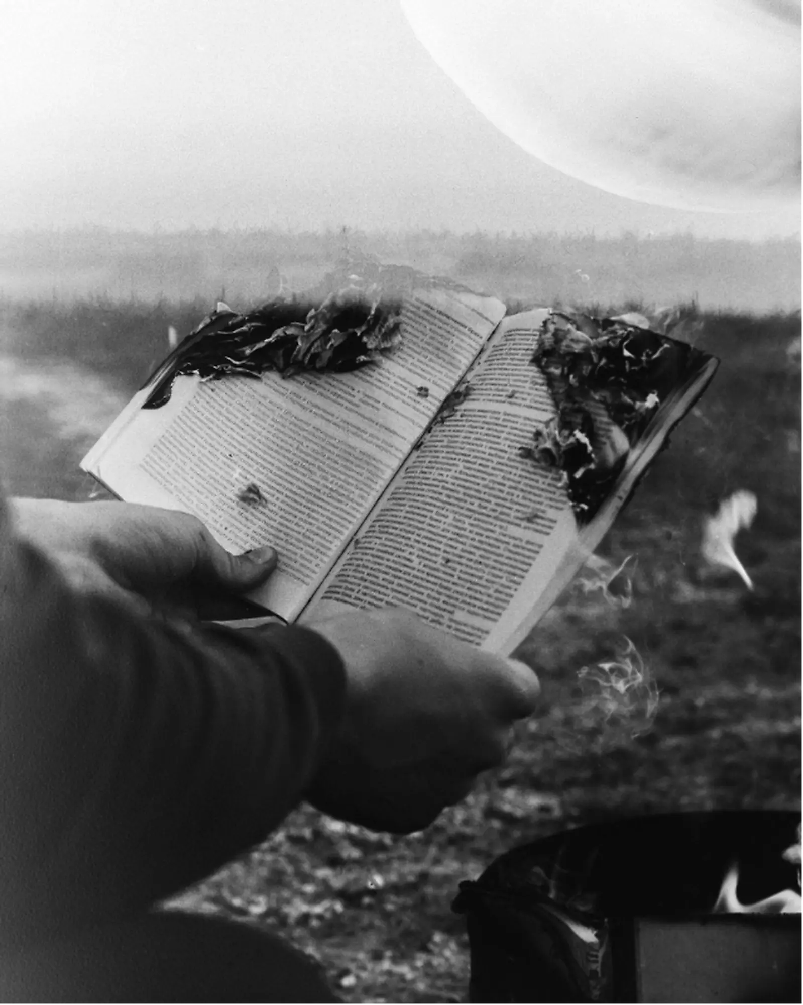 Person holding burning book